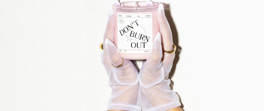 יד מחזיקה נר ורוד בזכוכית